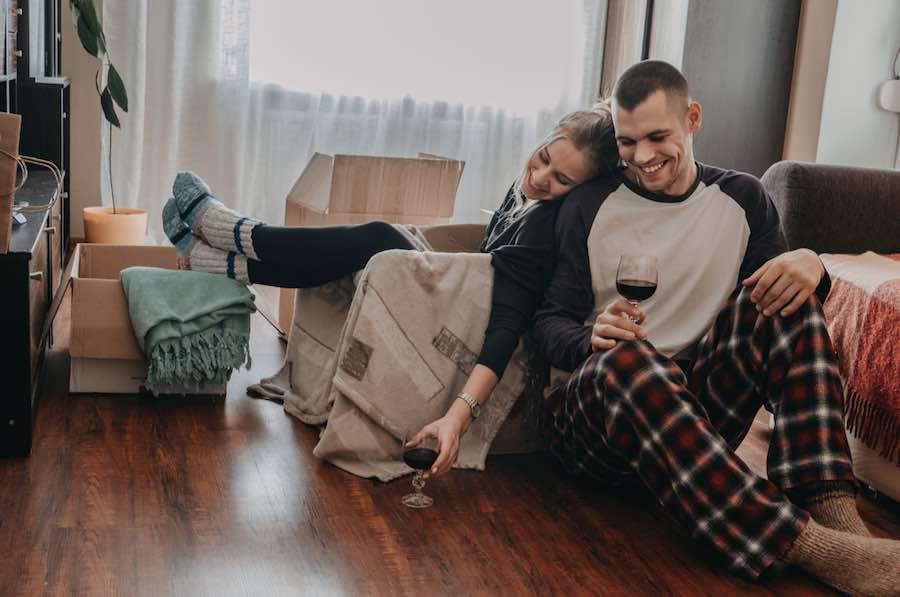 male and female couple sitting on the floor surrounded by moving boxes
